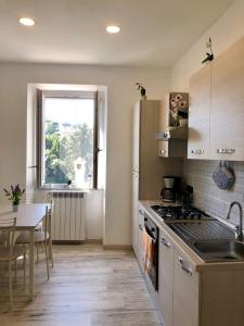 una cucina con piano cottura, tavolo e finestra di CASALE PRATOTERRA 2 a Bracciano