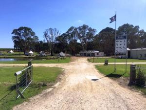 eine unbefestigte Straße mit Schild und Flagge in der Unterkunft Coonawarra Ensuite Unit D in Coonawarra