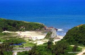 a beach with a bunch of umbrellas and the ocean at Hotel Jardim do Mar in Torres