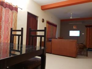 a dining room and living room with a table and chairs at SP Plaza Service Apartment in Trivandrum