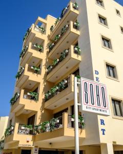a building with a slow sign in front of it at SOHO City Apartments in Larnaca