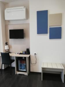 um quarto com uma secretária, um computador e uma televisão em Les Chambres de la Place em Sanremo