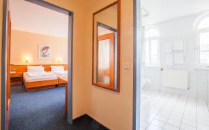 a hotel room with a bed and a bathroom at Sure Hotel by Best Western Wilhelmshaven City in Wilhelmshaven