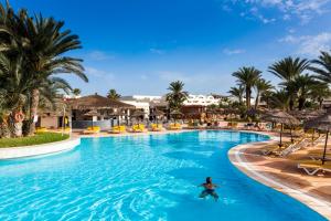 a person swimming in a swimming pool at a resort at TUI MAGIC LIFE Penelope Beach - Families & Couples in Midoun
