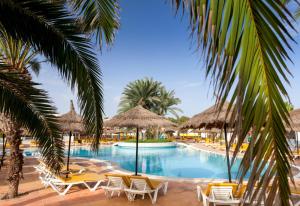 a pool at the resort with chairs and umbrellas at TUI MAGIC LIFE Penelope Beach - Families & Couples in Midoun