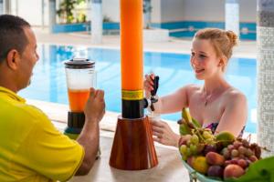 a man and a woman sitting at a table with a bowl of fruit at TUI MAGIC LIFE Penelope Beach - Families & Couples in Midoun