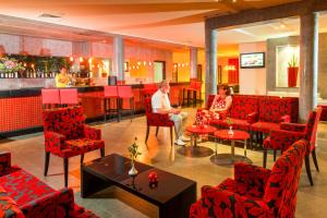 two people sitting in a restaurant with red chairs at TUI MAGIC LIFE Penelope Beach - Families & Couples in Midoun