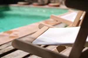 una silla sentada en una mesa junto a una piscina en Casa Migdia, en Sant Jordi Desvalls