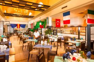 a restaurant with tables and chairs with a chef in the middle at TUI MAGIC LIFE Penelope Beach - Families & Couples in Midoun