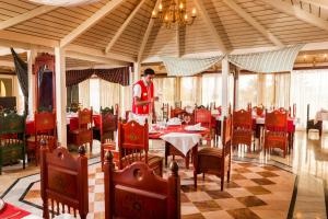 a man standing in a dining room with tables and chairs at TUI MAGIC LIFE Penelope Beach - Families & Couples in Midoun
