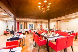 a man standing in a dining room with tables and red chairs at TUI MAGIC LIFE Penelope Beach - Families & Couples in Midoun