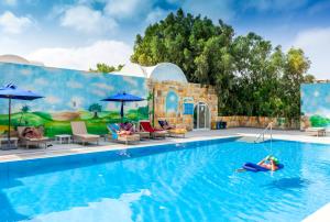 a pool at the resort with a person floating in the water at TUI MAGIC LIFE Penelope Beach - Families & Couples in Midoun