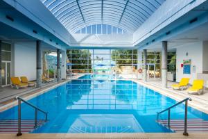 a large swimming pool with blue water and yellow chairs at TUI MAGIC LIFE Penelope Beach - Families & Couples in Midoun
