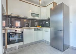 a large kitchen with a stainless steel refrigerator at Sweetime Apartment in Podstrana in Podstrana