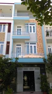 a white building with a door and a balcony at 846E16homestay in Vung Tau
