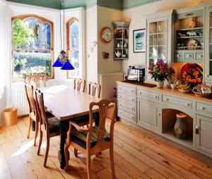 a kitchen with a wooden table and chairs at Alma House Bed and Breakfast in Newbury