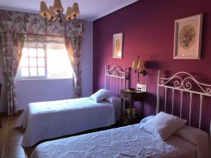 RosalにあるHostal Juanの紫色のベッドルーム(ベッド2台、窓付)