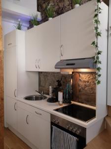 una cucina con armadi bianchi e lavandino di City Apartments a Gottinga