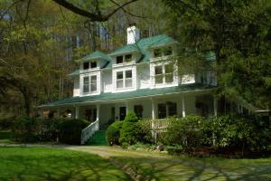 a large white house with a green roof at Taylor House Inn in Banner Elk