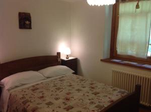 a bedroom with a bed with a quilt on it at B&B Le Temps d'une Pause in Champorcher