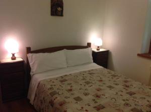 una camera da letto con un letto con due lampade su entrambi i lati di B&B Le Temps d'une Pause a Champorcher
