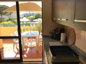 uma cozinha com vista para um pátio com uma mesa em Apartament Olhos do Mar T1 beach Olhos de Água em Albufeira