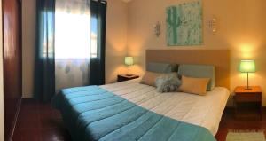 1 dormitorio con 1 cama grande con manta azul en Apartament Olhos do Mar T1 beach Olhos de Água en Albufeira