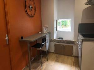 a kitchen with a table and a clock on the wall at La cabine de Loire in Saint-Satur