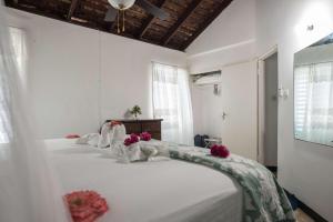 a bedroom with two beds with white sheets and pink flowers at Beach Palms Villa in Silver Sands +19 photos