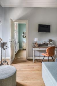 a living room with a desk and a television at Villa Copis in Borgloon