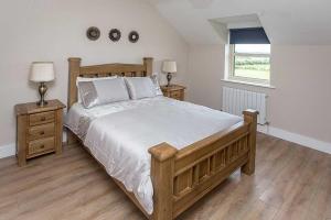 una camera con un grande letto e due comodini di Greenway Holiday Home a Dungarvan