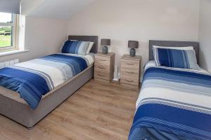 1 dormitorio con 2 camas y ventana en Greenway Holiday Home, en Dungarvan