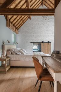 a bedroom with a large bed and a wooden desk at Villa Copis in Borgloon