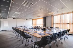 a large conference room with a long table and chairs at La Maison Hôtel Mulhouse Centre in Mulhouse