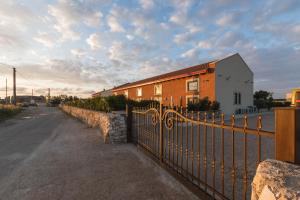 una recinzione di fronte a un edificio con una casa di Palascìa Wellness Relais a Otranto
