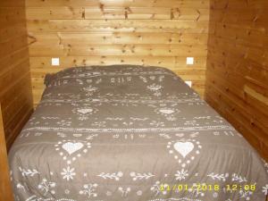 Les RibesにあるLe Pin Cembroの木製の部屋にベッド1台が備わるベッドルーム1室があります。