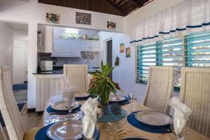 comedor con mesa y sillas y cocina en Beach Palms Villa, en Silver Sands