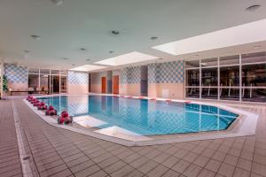 a large swimming pool with red chairs around it at Hotel La Mar in Kielce