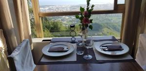 a table with two plates and a vase with flowers at Hotel Ristorante Radar in Carrara