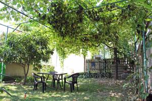 a table and chairs under a tree in a yard at Hotel Liva in Mtskheta