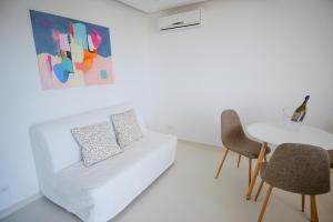 a living room with a white couch and a table at Apartamentos Pinhão in Lagos