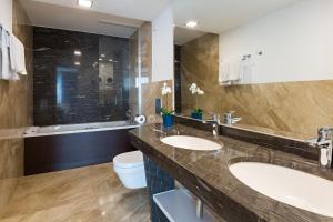 a bathroom with two sinks and a tub at Abba Hotel in Belgrade