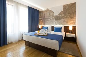 a bedroom with a large bed with blue and white at Abba Hotel in Belgrade