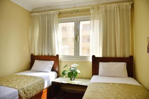 Two-Bedroom Apartment at Mohamed Farid Street في القاهرة: سريرين في غرفة صغيرة مع نافذة