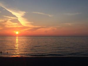 カーポ・ドルランドにあるCordovenaの海上の人々と一緒に海辺の夕日