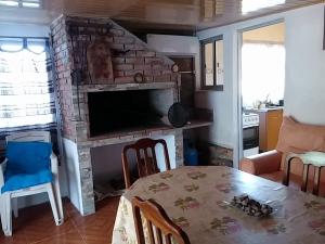 a living room with a table and a brick fireplace at La Quimera a pasos de la playa in Atlántida
