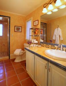 uma casa de banho com um lavatório, um WC e um espelho. em L'Auberge Provencale Inn & Restaurant em Boyce