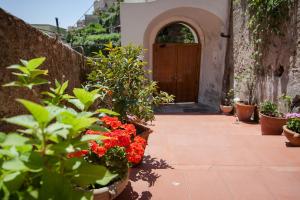 a courtyard with potted plants and a wooden door at Hotel L'Argine Fiorito in Atrani