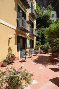 a patio with tables and chairs in front of a building at Hotel L'Argine Fiorito in Atrani