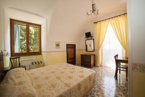 a bedroom with a bed and a table and a window at Hotel L'Argine Fiorito in Atrani